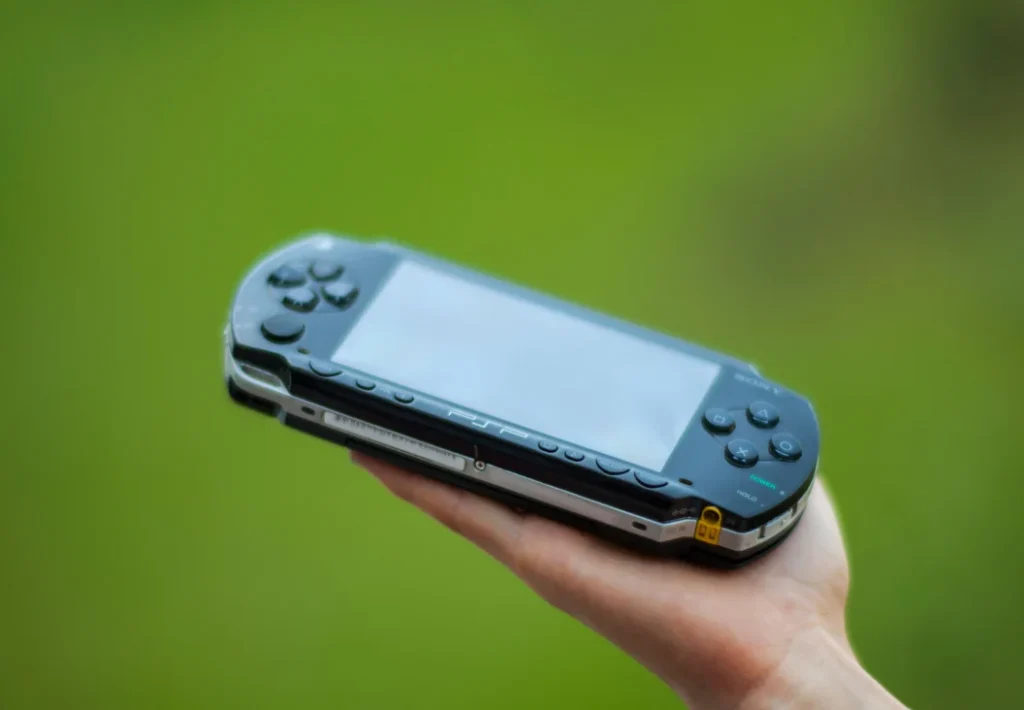 Blue Sony PSP handheld held outdoors